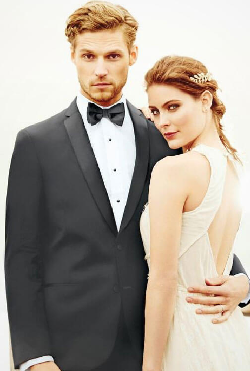 Photo of bride and groom wearing a black tuxedo